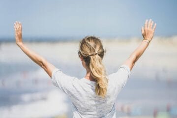 woman with arms stretched up and out in front of her